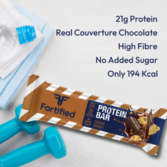 (Cookie Dough) Protein bar with chocolate flavor, shown with a bottle of water and dumbbells on a light background.