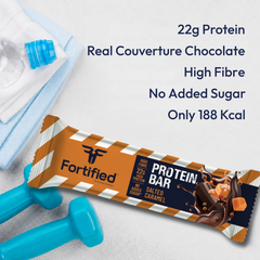 (Salted Caramel) Fortified protein bar with chocolate flavor, shown with a water bottle and dumbbells on a light background.